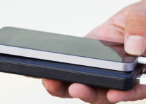 Man holding phone and charging it with battery pack