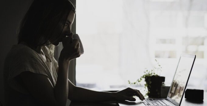 Woman drinking coffee learning how to choose a VPN on her laptop