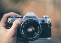 person holding black Canon DSLR camera