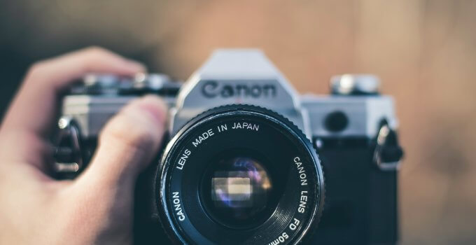 person holding black Canon DSLR camera