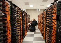man in black jacket sitting on brown wooden chair in VPS server room