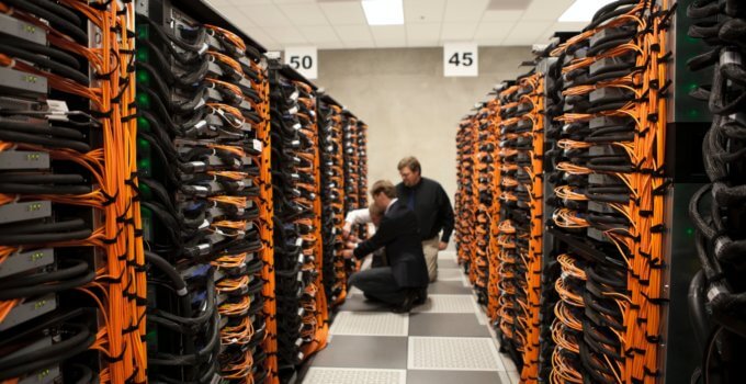 man in black jacket sitting on brown wooden chair in VPS server room
