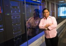 woman standing near wall of web servers