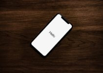 turned on iPhone on top of brown wooden surface