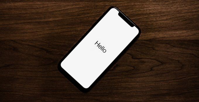 turned on iPhone on top of brown wooden surface
