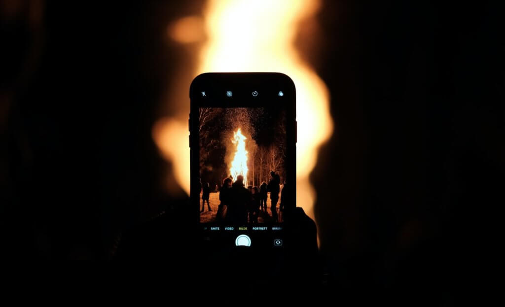 Black iPhone 5 showing fire pit in the woods
