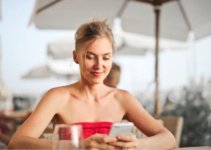 Woman sitting on a chair at a restaurant typing on her smartphone