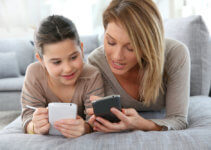 Mother and daughter playing games with smartphone