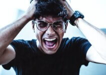 frustrated and exacerbated man in black crew neck t-shirt screaming in front of his computer