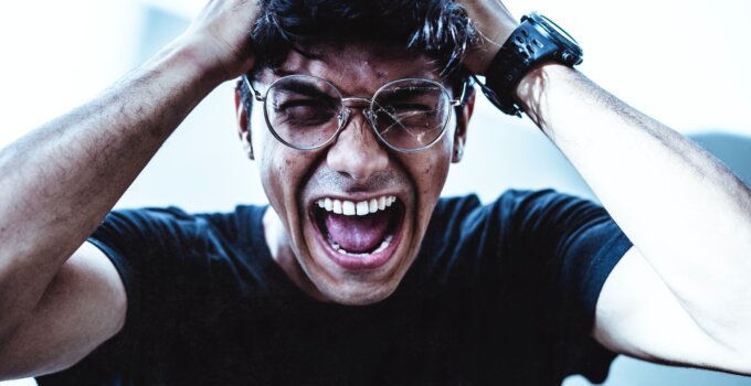 frustrated and exacerbated man in black crew neck t-shirt screaming in front of his computer