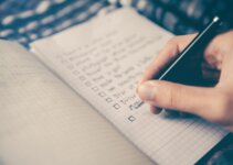 Person writing website audit checklist on a notepad