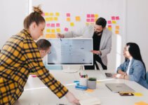Man pitching ideas to his team in front of flat screen TV to prepare for investor meeting