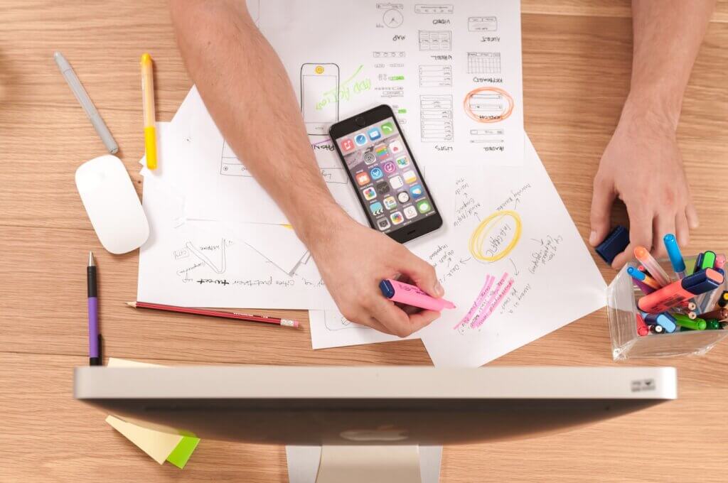 Person writing on white paper planning digital marketing campaign using SEO
