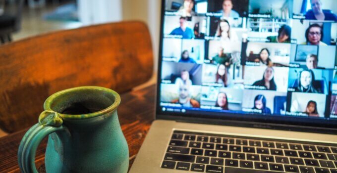 Laptop on desk with cup of tea using iMind online video conferencing