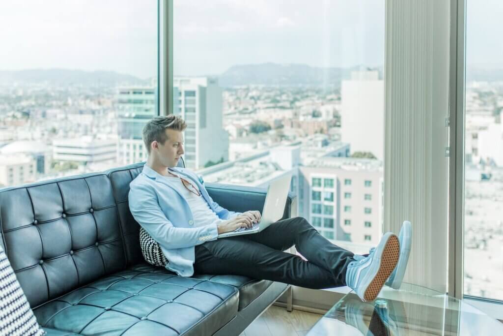 Man sitting on sofa while using a laptop for writers